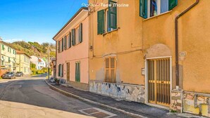 A narrow street with buildings on either side, featuring a mix of architectural styles and a clear sky. - Discover your oasis of relaxation in Pitelli, a charming village overlooking the sea! We present you a splendid holiday home ideal for families and groups of up to 4 people.The house consists of two welcoming and tastefully furnished bedrooms, perfect fo (Pitelli)