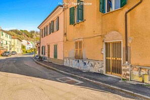 Eine schmale Straße mit Häusern an beiden Seiten, die verschiedene Baustile zeigen, unter einem klaren Himmel.