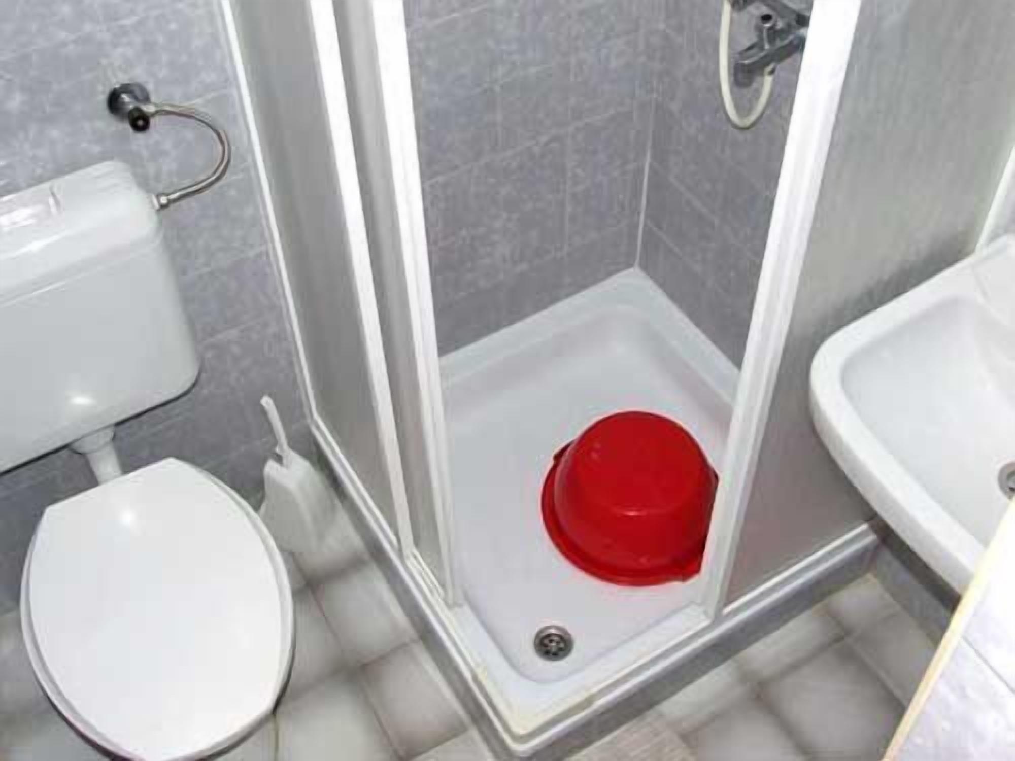 Une salle de bain comprenant des toilettes, un lavabo et une cabine de douche.