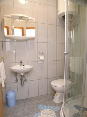 A bathroom with a sink, toilet, and glass shower enclosure. - Apartments Ljiljana (Smokvica)