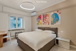 Un dormitorio con cama, mesita de noche y ventana.