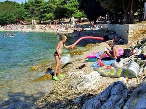 Une plage où l’on peut se baigner et bronzer, un rivage rocheux et une mer d’un bleu limpide.