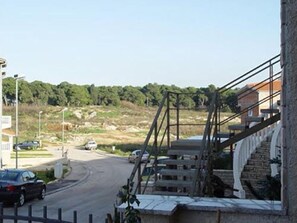 Une vue de rue avec un pont, des immeubles et des voitures garées.