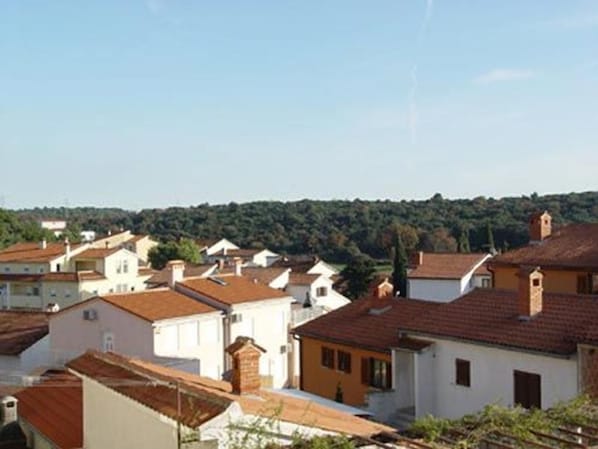 A residential area with houses featuring red-tiled roofs and white walls, surrounded by greenery. - Apartment Mladen (Pula)