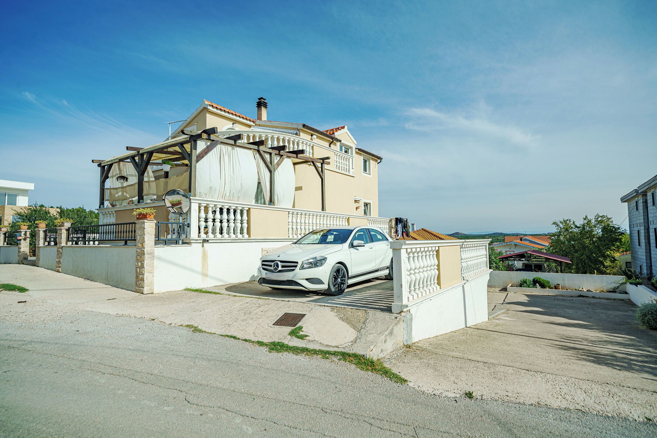 A two-story house with a car parked in front.