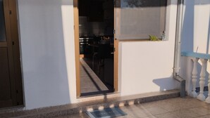 A modern building with a sliding glass door leading to a kitchen area. - Apartment Denis (Sibenik)