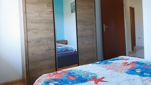 A bedroom with a bed, a wardrobe, and a door. - Apartment Denis (Sibenik)