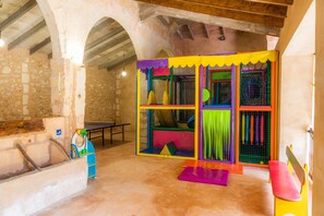 A play area with colorful play structures and a stone wall.
