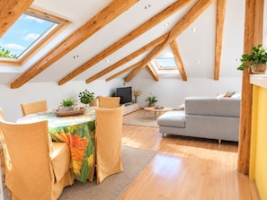 A modern loft with a dining area, seating, and a television. - Apartments Radomir (Fazana)