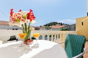Ein Tisch mit einer Blumenvase, zwei Orangensaftgläsern und einer Schüssel Erdbeeren.