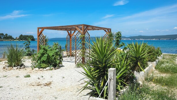 A wooden pergola structure with a view of the sea. - Apartments Seafront (Pasman)