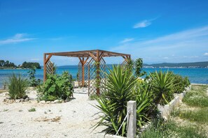 A wooden pergola structure with a view of the sea. - Apartments Seafront (Pasman)