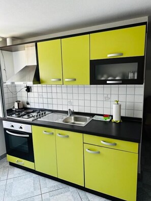 Apartamento (A6) | Cozinha privada | Geladeira, cooktop, chaleira elétrica