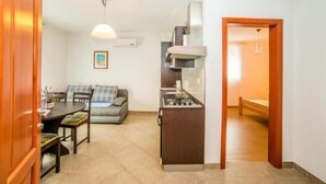 A compact living space with a kitchenette, a dining area, and a sofa. - Apartments Vladimir (Malinska-Dubasnica)