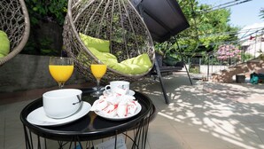 Ein Tisch mit einem Tablett voller Frühstücksleckereien, darunter ein Glas Orangensaft, eine Tasse und ein Teller mit Gebäck.