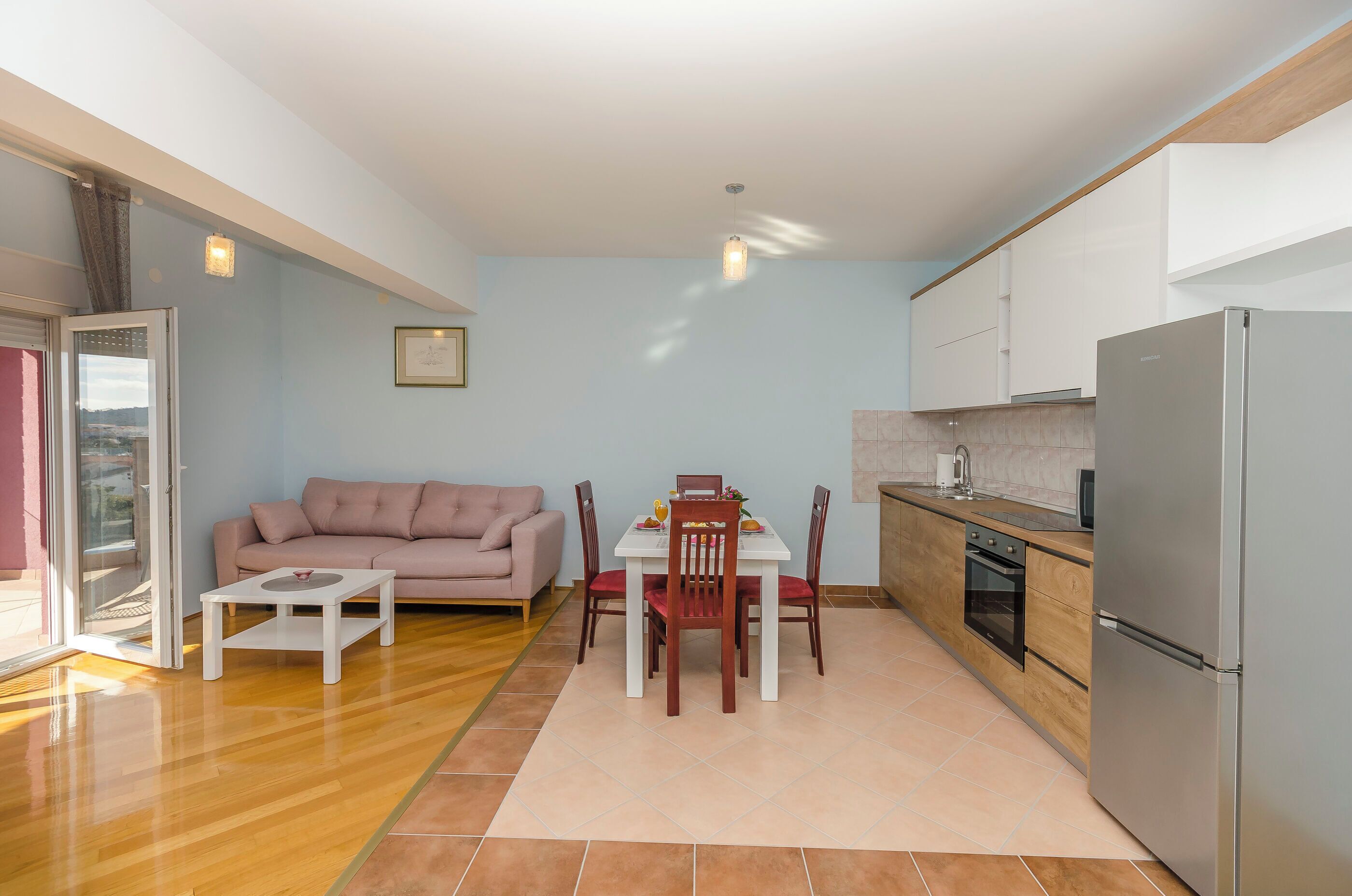 Un espacio habitable compacto con comedor, kitchenette y sofá.