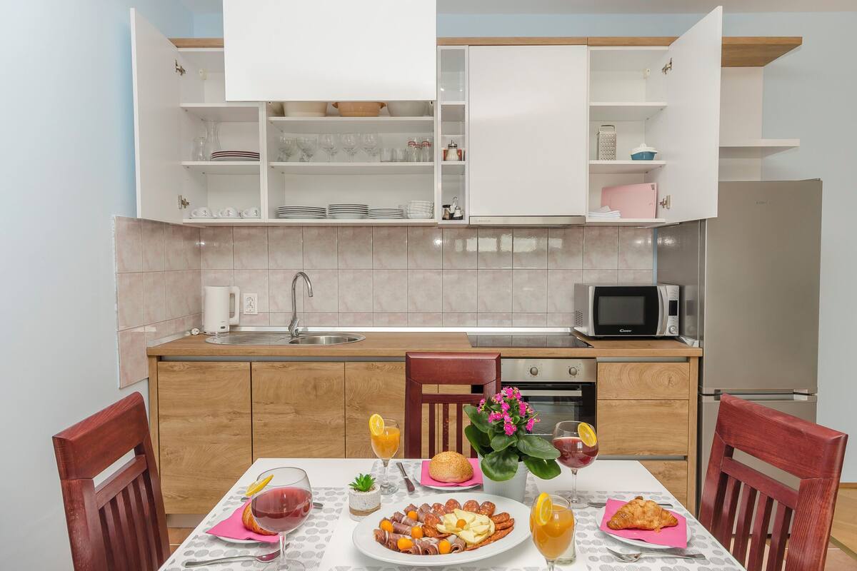 A modern kitchen with white cabinets, a microwave, and a refrigerator.