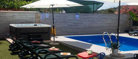 Alberca al aire libre y camastros