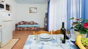 A compact living space with a dining area, kitchenette, and a sofa.