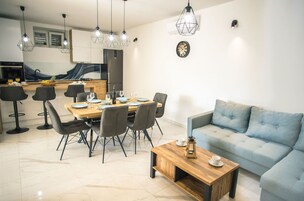 Una sala moderna con comedor, un sofá y una mesa de centro.