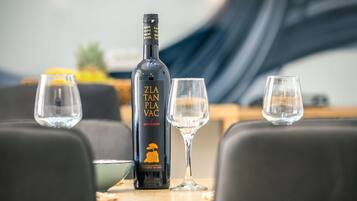 A bottle of ZLA TAN PLA VAC on a table with two empty glasses.