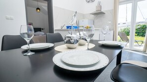 A dining area with a table set for four, including plates, glasses, and a pitcher. - Apartments Annela (Seget)