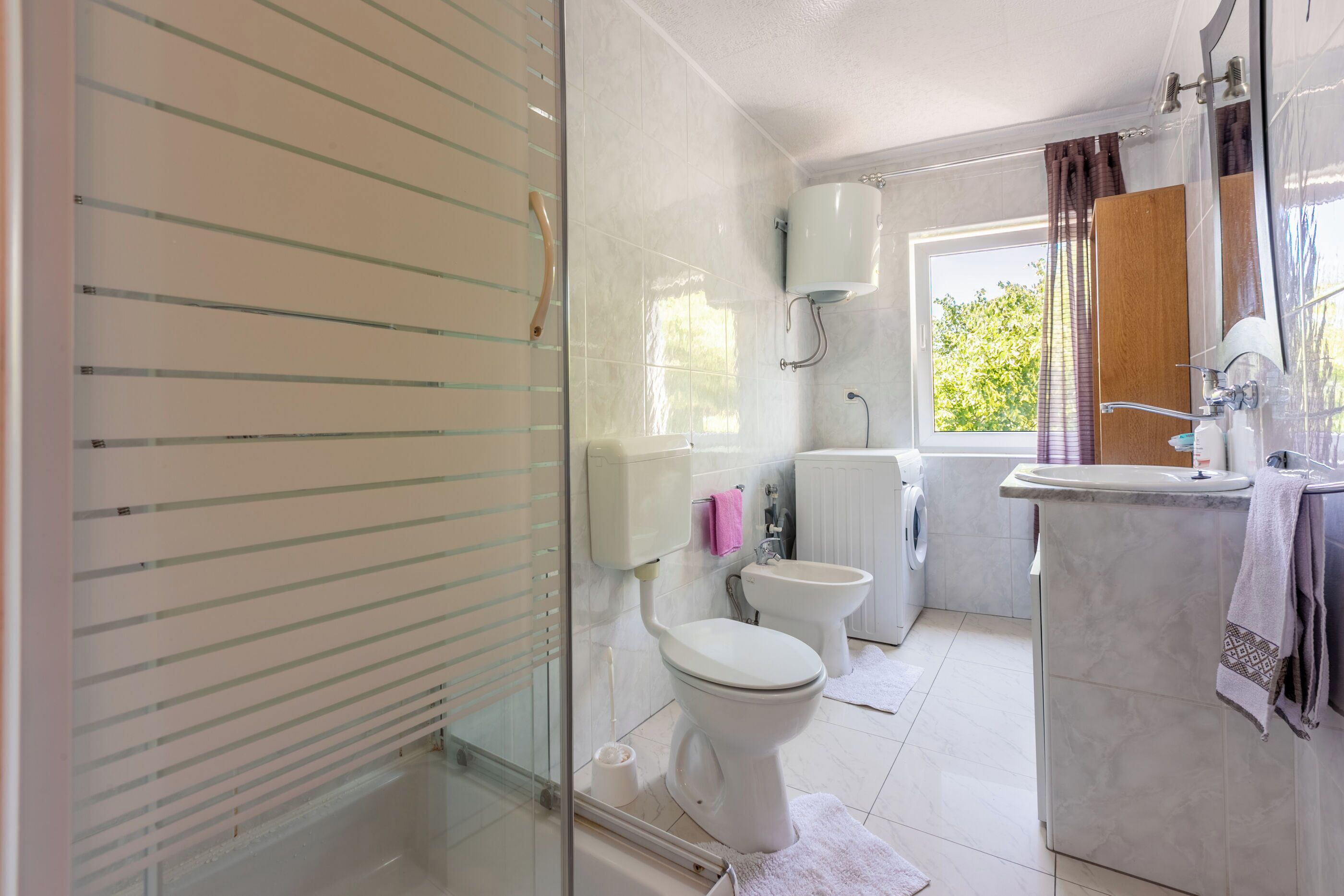A bathroom with a toilet, bidet, and sink.