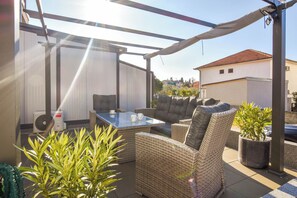 An outdoor patio area with wicker furniture, a glass table, and a ceiling fan. - Apartment Martin (Biograd na Moru)
