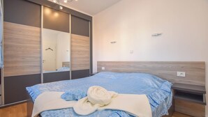 Una camera da letto con un letto, una testiera in legno, uno specchio e un comodino.