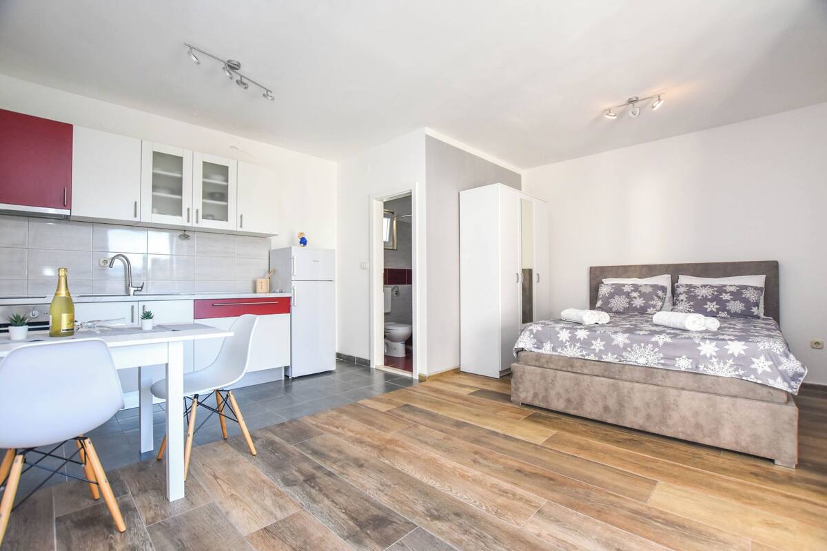 Un appartement moderne comprenant une cuisine, un coin repas et une chambre.