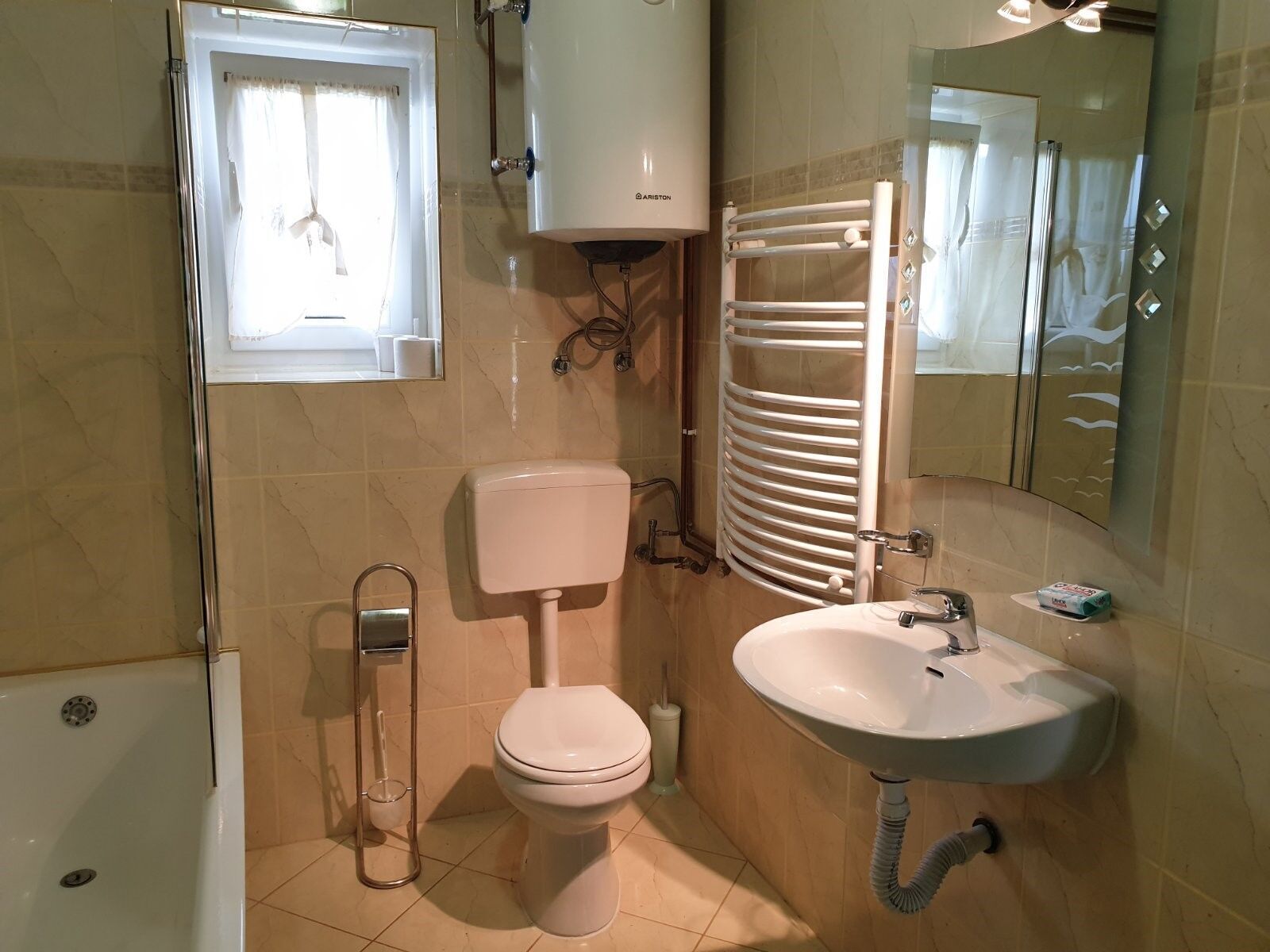 A bathroom with a toilet, sink, and a towel rack.