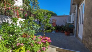Un patio con plantas en macetas y un mural de un personaje de caricatura en una pared.