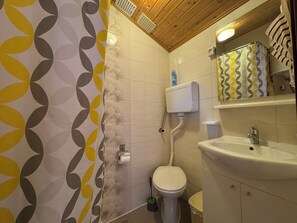 Un baño con inodoro, lavabo y cortina de ducha.