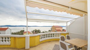 A balcony with a view of the sea, a table, and chairs. - Apartments Dandelion (Biograd na Moru)