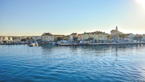 A waterfront cityscape with buildings, a marina, and calm water. - Apartments Dandelion (Biograd na Moru)