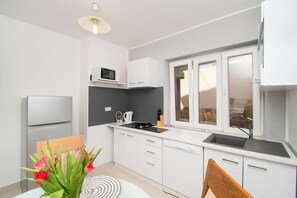 Appartement (A1) | Cuisine privée | Réfrigérateur, four à micro-ondes, surface de cuisson, lave-vaisselle