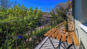 A balcony with a wooden table, a bottle of wine, and a glass. - Apartment Alej (Senj)