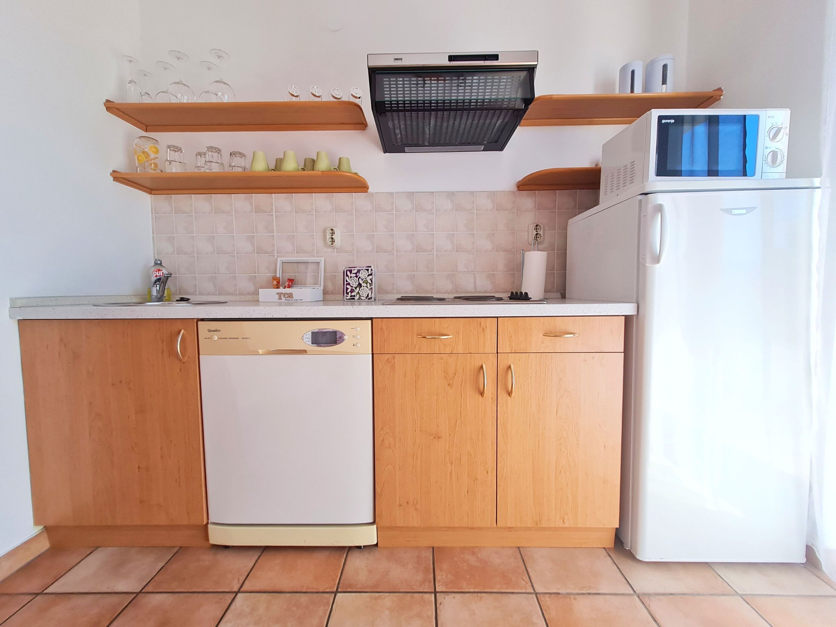 A kitchen with wooden cabinets, a dishwasher, a microwave, and a built-in oven.