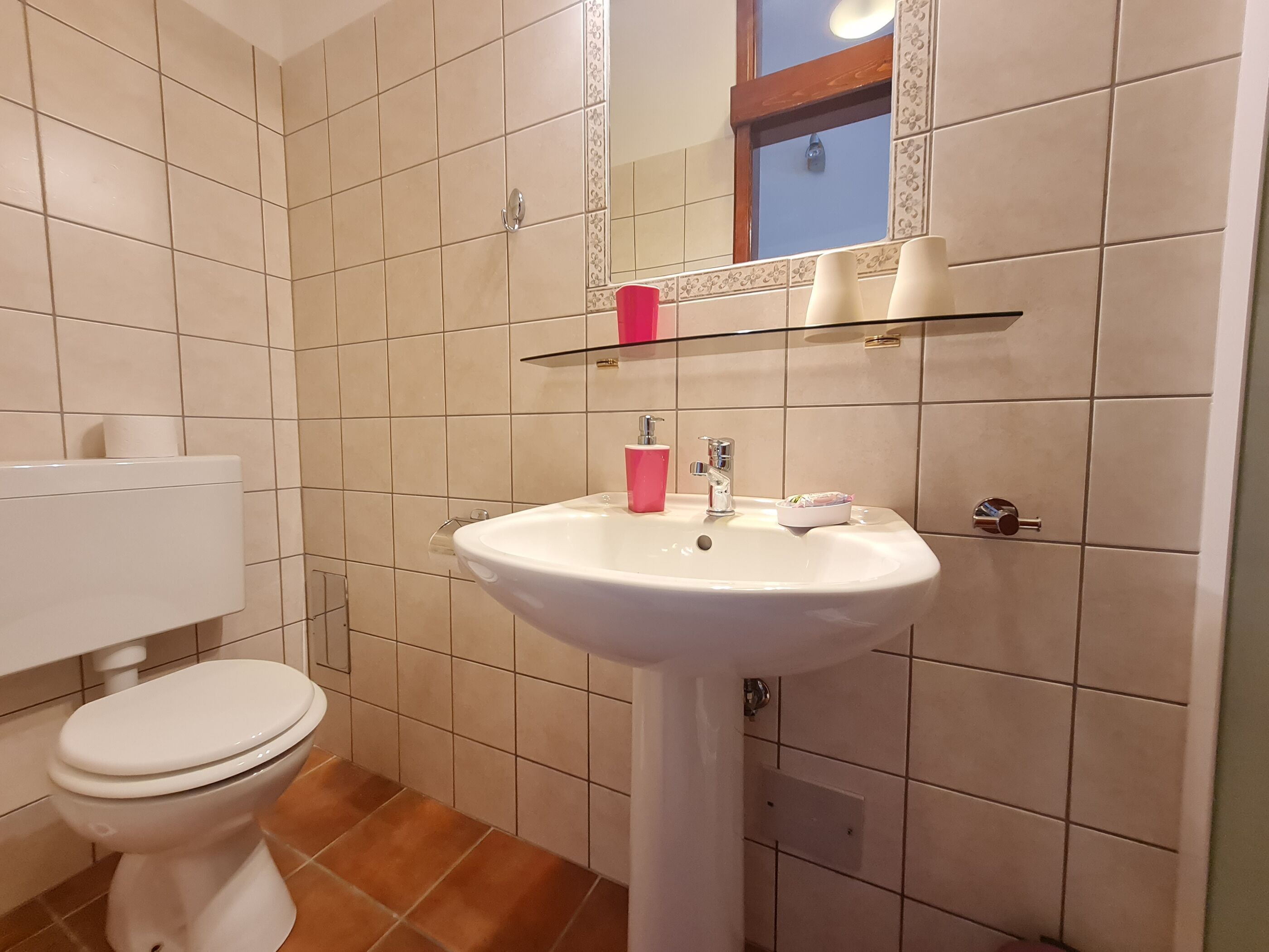 A bathroom with a white toilet, a white sink, and a mirror above the sink.