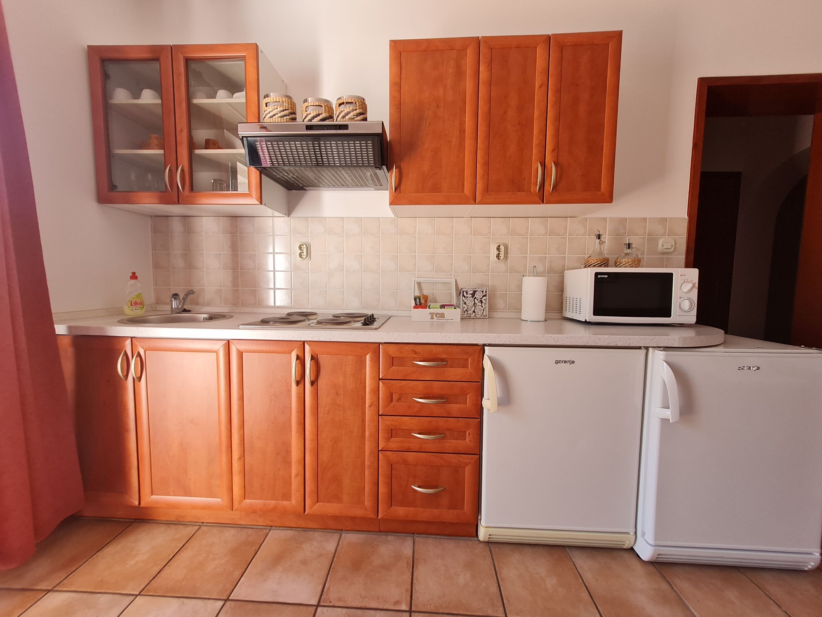 A kitchen with wooden cabinets, a white refrigerator, a microwave, and a sink.