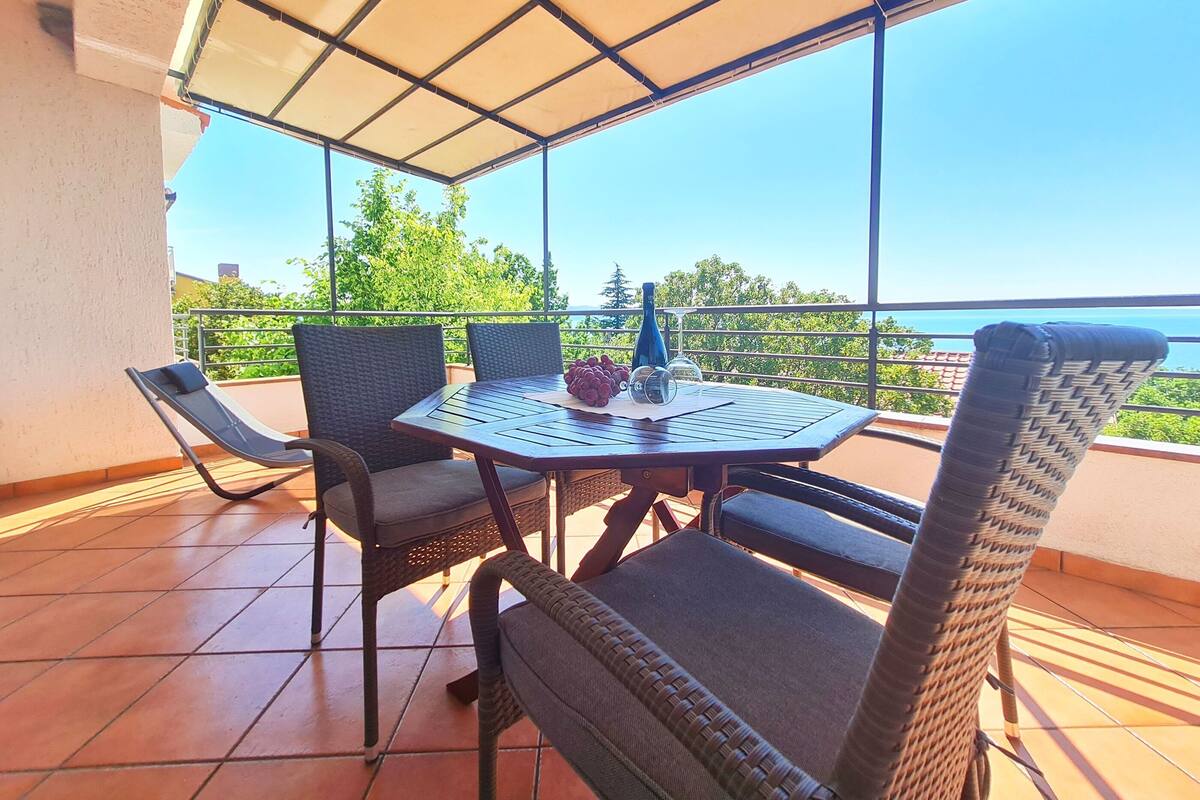 Un espace extérieur abrité, avec une table et des chaises, offrant une vue panoramique.