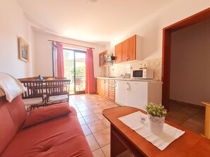 A compact living space with a kitchenette, a dining area, and a sofa. - Apartments Zelena Oaza (Novi Vinodolski)