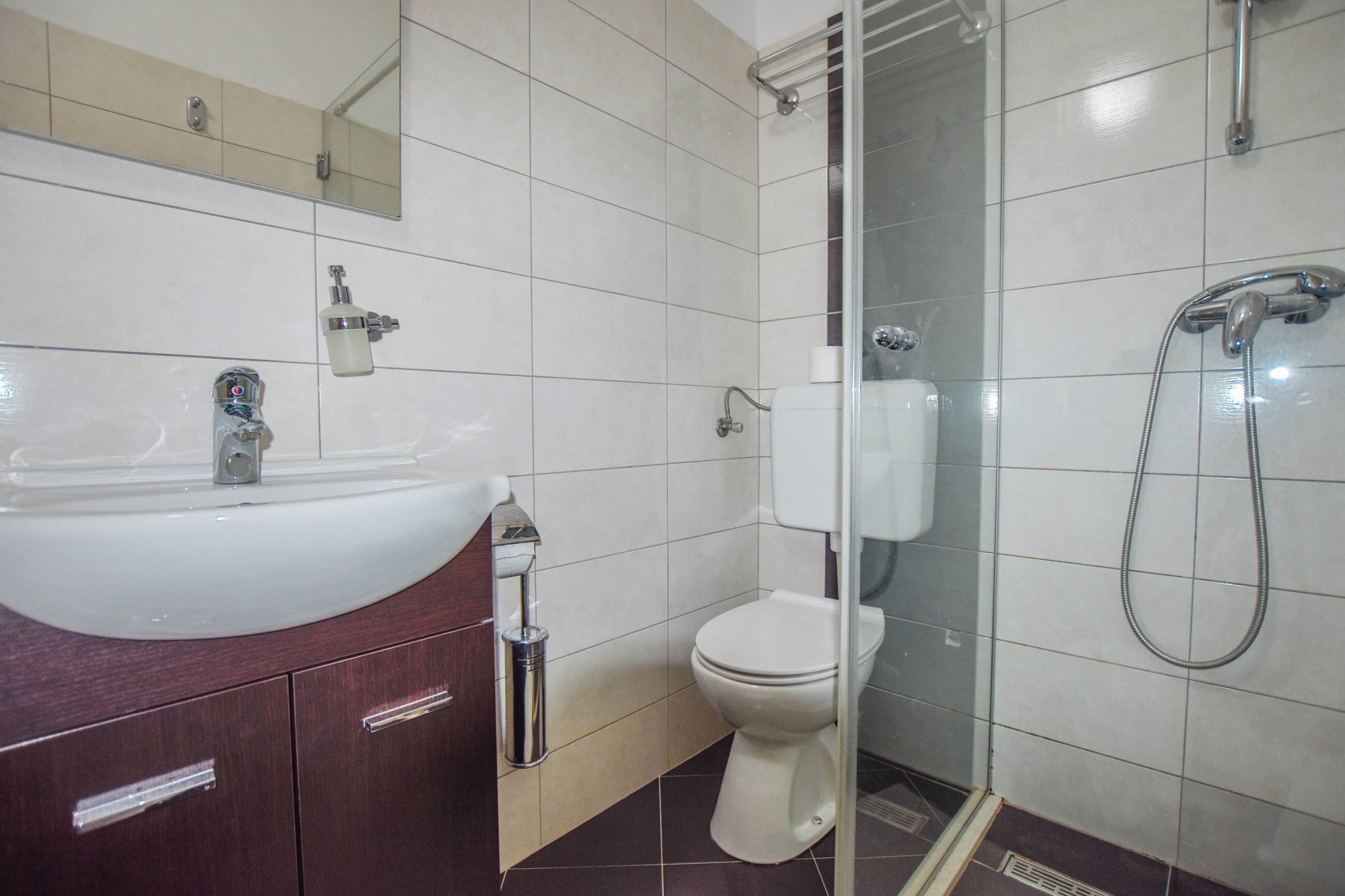 A bathroom with a sink, toilet, and shower.