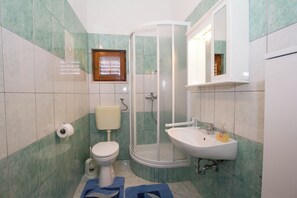 Kylpyhuone, jossa on wc, pesuallas, suihku ja ikkuna.