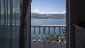 Ein Balkon mit Blick auf das Meer und die Berge.