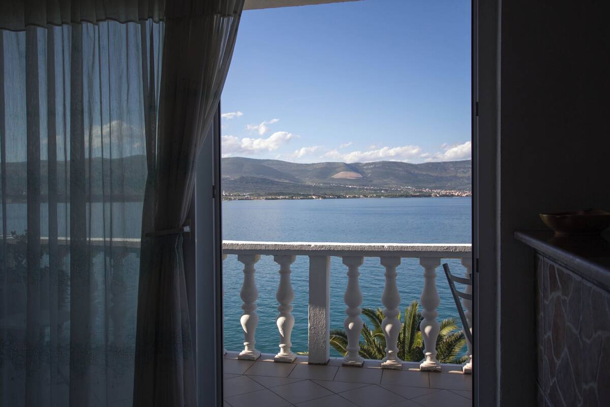 Un balcon avec vue sur la mer et les montagnes.