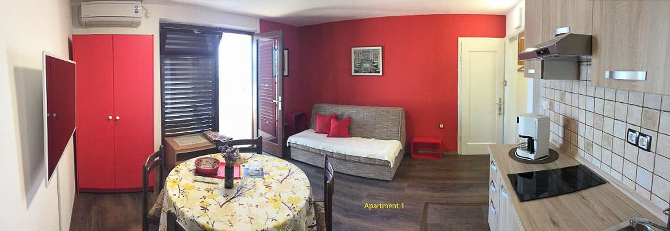 Un appartement compact comprenant un coin repas, un lit et une kitchenette.