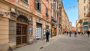 Eine historische Straße mit Kopfsteinpflaster, traditioneller Architektur und verschiedenen Geschäften.