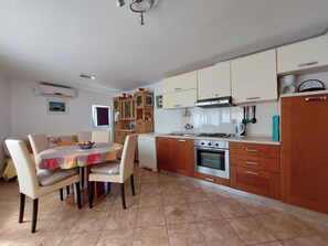 Cocina compacta con comedor, que incluye estufa, horno y alacenas.