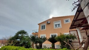 A multi-story building with a flat roof, air conditioning units, and a balcony. - Apartments Mladen (Okrug)
